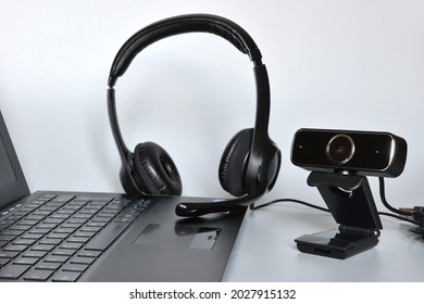 Notebook with headphones with mic and a webcam, concept of smart working or online communications.