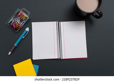 Notebook With Important Messages On Both Sides On Desk With Coffee, Pen, Paperclip And Memos. Crutial Information On Pad On Table With Cup And Pencil. Late Updates Presented.