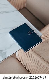 Notebook, Journal, blue diary add your own logo or text, mockup, coffee and table in a cafe 