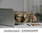 Notebook, laptop and pen on white table indoors. Military education