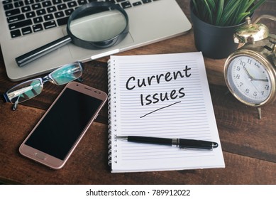 notebook, laptop, smartphone, clock and pen with CURRENT ISSUES word on a wooden background. current issues concept - Shutterstock ID 789912022