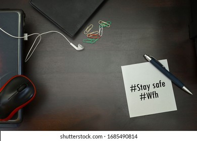 Notebook, Laptop And Stay Safe Note Isolated On Wooden Background.  A Stay Safe And Work From Home Concept Due To Virus.