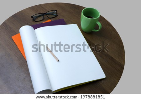 notebook mug of fresh coffee and eyeglasses on brown wooden backdrop