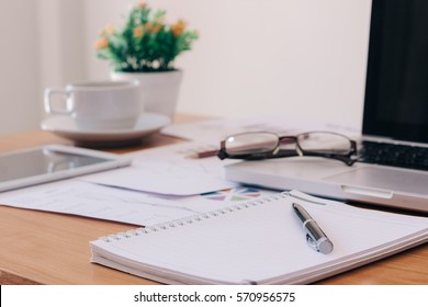 notebook or notepad blank with a pen on top and laptop put on right side, It has been on office desk for work, business concept.