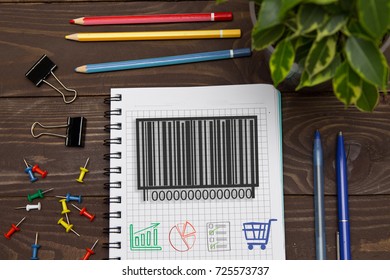 Notebook with a notes barcode product on the office table with tools. Concept with elements of infographics.