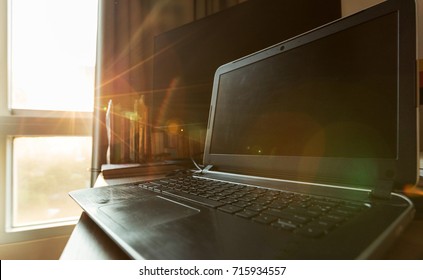 Notebook on table in workspace with sunlight outside window.Overexposure shot to get flare