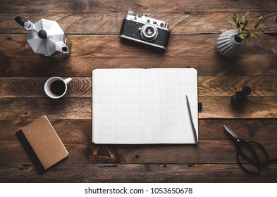 Notebook on wooden table template with,  camera, coffee cup, plant and copy. Flat lay. - Powered by Shutterstock