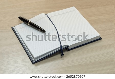The notebook opens on blank sheets with a large fountain pen lying on them. Be prepared for new ideas, plans, or stories. The concept of a 
