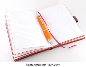 Notebook and orange pen