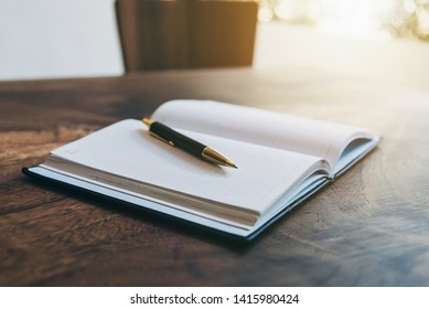 Notebook paper on dark wood table with blurry nature background. - Powered by Shutterstock