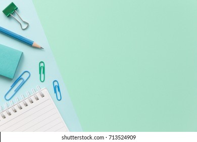 Notebook Paper, Pencil, Paper Clip And Sticky Note On Pastel Office Desk With Copy Space