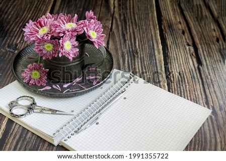 Notebook, pen, Chrysanthemums in a vase and decorative scissors. Businesswoman set. Case planning concept. Diary. BusinessConcept. High quality photo