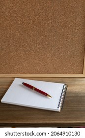 Notebook with pen and cork board frame background at table in office. Student home workplace