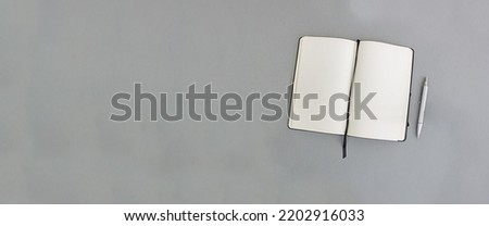 Notebook and pen on a gray background, copy space. Banner