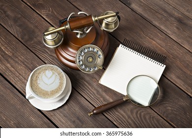 Notebook with a pen on the table next to coffee and phone