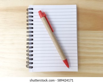 A notebook and pen on wood background