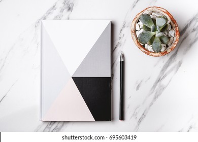 Notebook, Pen And Succulent On Marble Table. Flat Lay