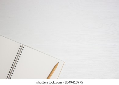 A notebook with pencil on a white table.  - Shutterstock ID 2049413975