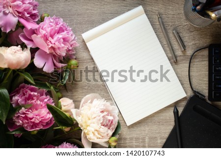 notebook with peony, tablet and keyboard
