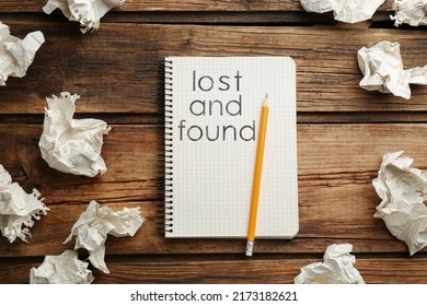 Notebook With Phrase Lost And Found, Pencil, Crumpled Sheets Of Paper On Wooden Background, Flat Lay