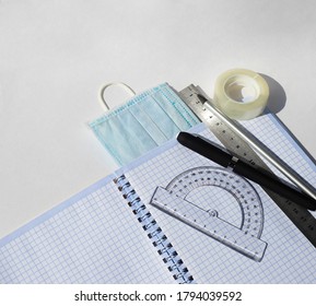  Notebook Protractor Ruler Pencils Pens Scotch Tape And Medical Masks. Study And Work During A Pandemic.