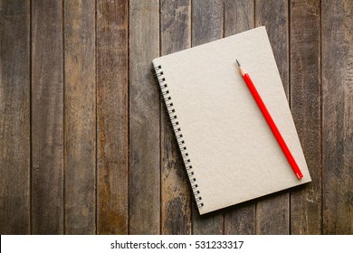 notebook with red pencil on wooden table, Vintage picture tone - Powered by Shutterstock