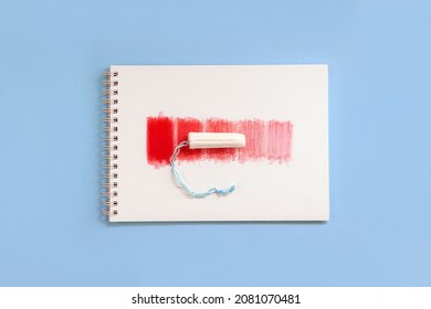 Notebook With Red Rectangles And Feminine Hygiene Tampon. Concept Intensity Of Menstrual Flow. Top View