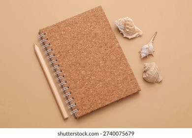 Notebook and seashells on a brown background