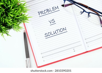 A notebook shows the words problem and solution written clearly. A pen and a pair of glasses rest beside it. A small plant adds a touch of green to the scene.