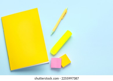 Notebook, sticky notes, pen and marker on color background