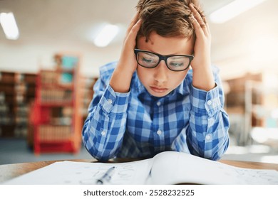 Notebook, stress and boy in classroom for study, test and child development with anxiety in education. Desk, assessment and frustrated student with learning disability, notes or exam at middle school