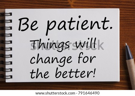 Notebook with text " Be patient.Things will change for the better!"on wooden background.