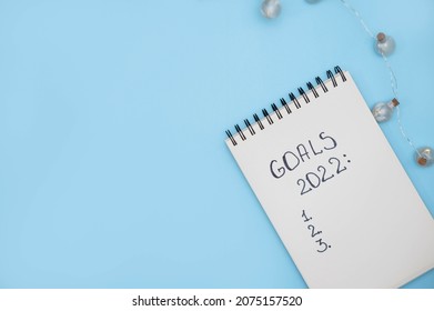 Notebook with text GOALS 2022 on  blue background. Motivation, inspiration. Planning, plans and tasks. New business ideas. Setting goal, target. - Shutterstock ID 2075157520