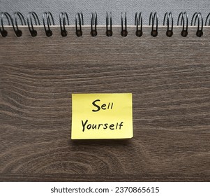 Notebook with text handwritten note SELL YOURSELF, concept self marketing in professional business world to get hiring or make money with or writing from customers