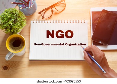 Notebook with text inside NGO (or Non-Governmental Organization)  on table with coffee. - Shutterstock ID 403095553