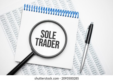 In The Notebook Is The Text Of Sole Trader, Next To The Black Pen, Magnifying Glass. A Business Concept.