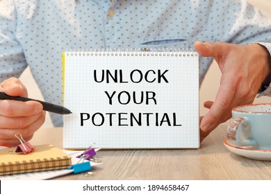 Notebook with the text - Unlock Your Potential - on the office table among the stationery.