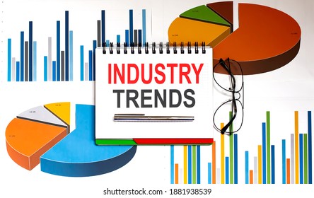Notebook with Tools and Notes with text Industry trends on charts