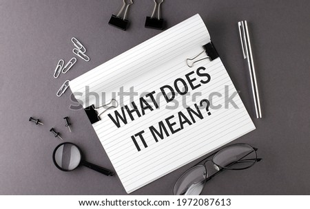 Notebook with Tools and Notes with text WHAT DOES IT MEAN , business