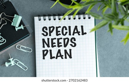 A notebook with the words Special Needs Plan written on it. The notebook is on a table with a pair of scissors and a pair of green paper clips