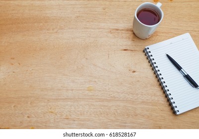 Notebook,pen,coffee on desk table. Top view  copy space