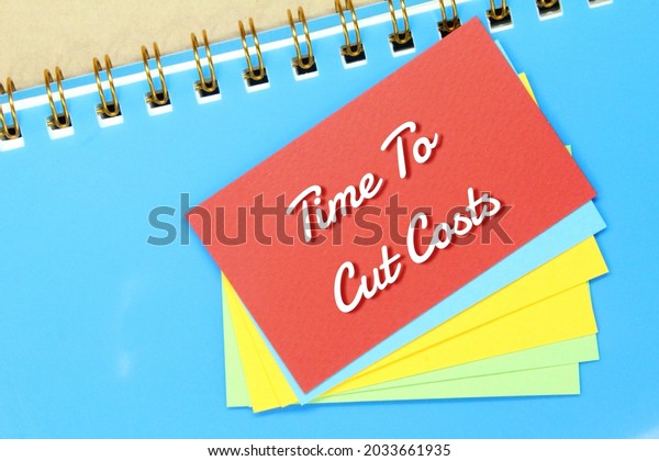 notebooks,\
colored paper with the words time to cut\
costs