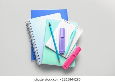 Notebooks, pen, pencil and markers on light background