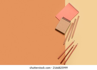 Notebooks with pencils on color background