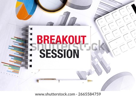Notepad with breakout session text on a desk with charts and calculator . 