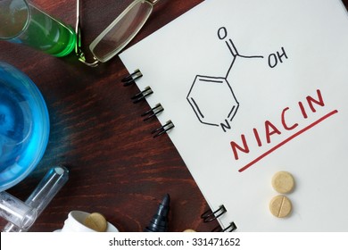 Notepad with chemical formula of  Niacin (vitamin b3) on the wooden table.
