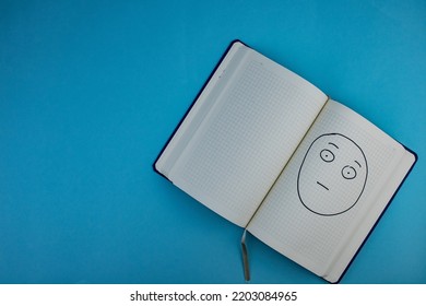 Notepad With Clear Eyes And Confused Facial Expression Placed On Blue Background.