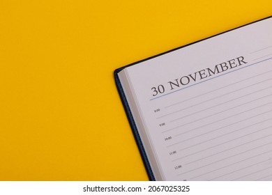 Notepad or diary with the exact date on a yellow background. Calendar for November 30 - autumn time. Space for text.