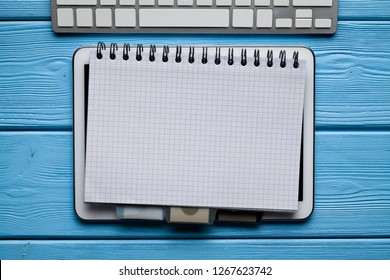 Notepad, digital tablet and computer keyboard on wooden table - Powered by Shutterstock