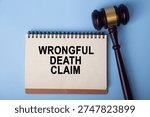 Notepad displaying wrongful death claim next to a wooden gavel on blue background